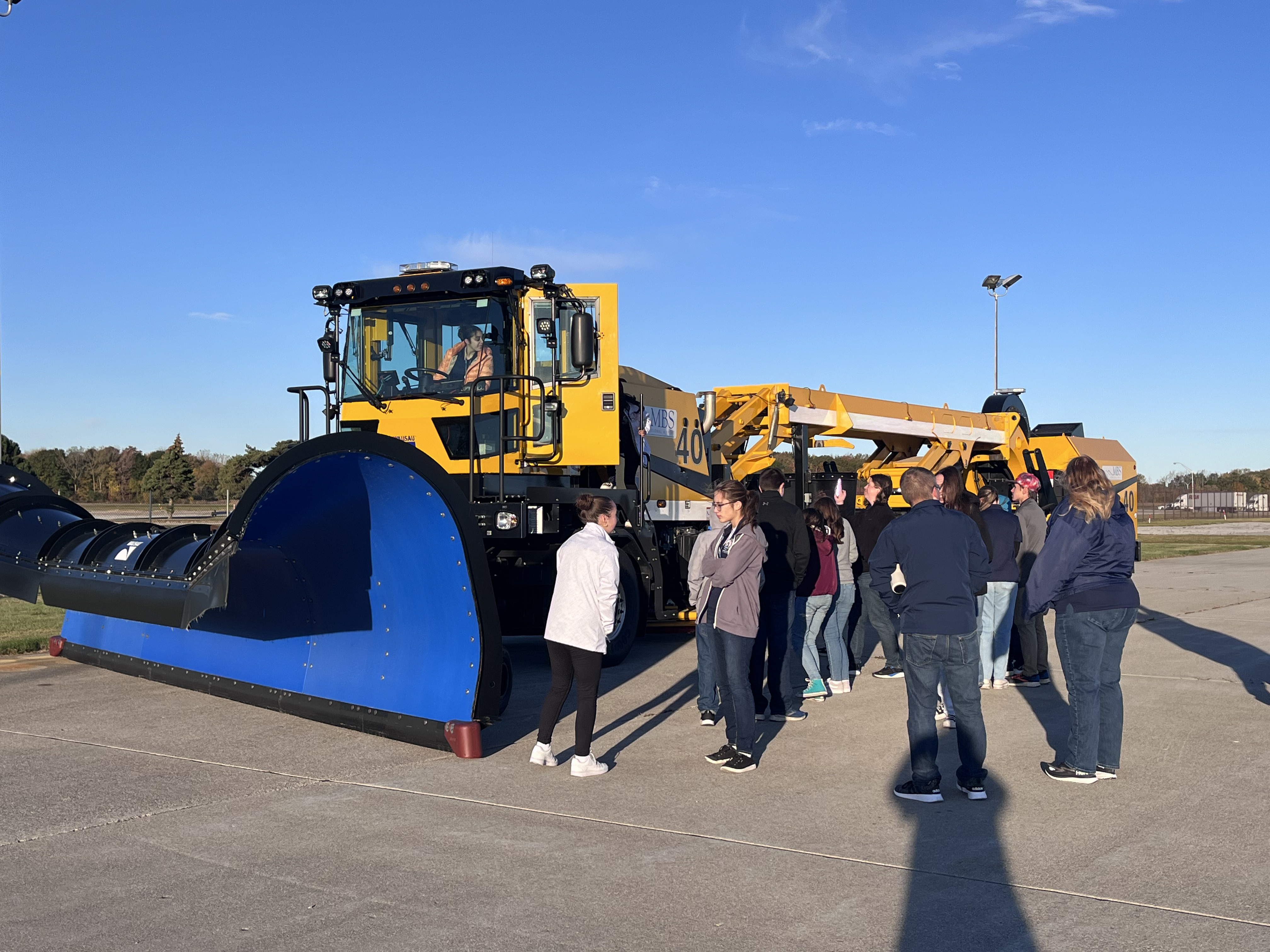 Students learning about snow plow at airport
